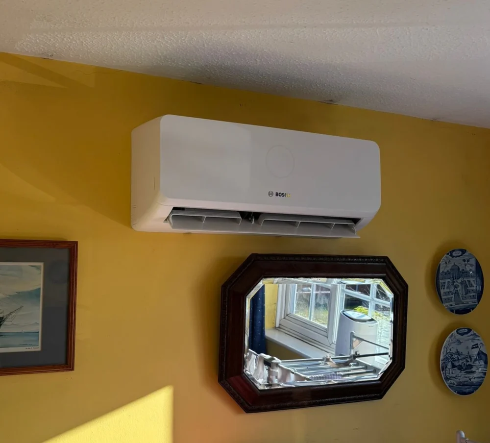 A Bosch indoor wall unit on a yellow wall above a mirror