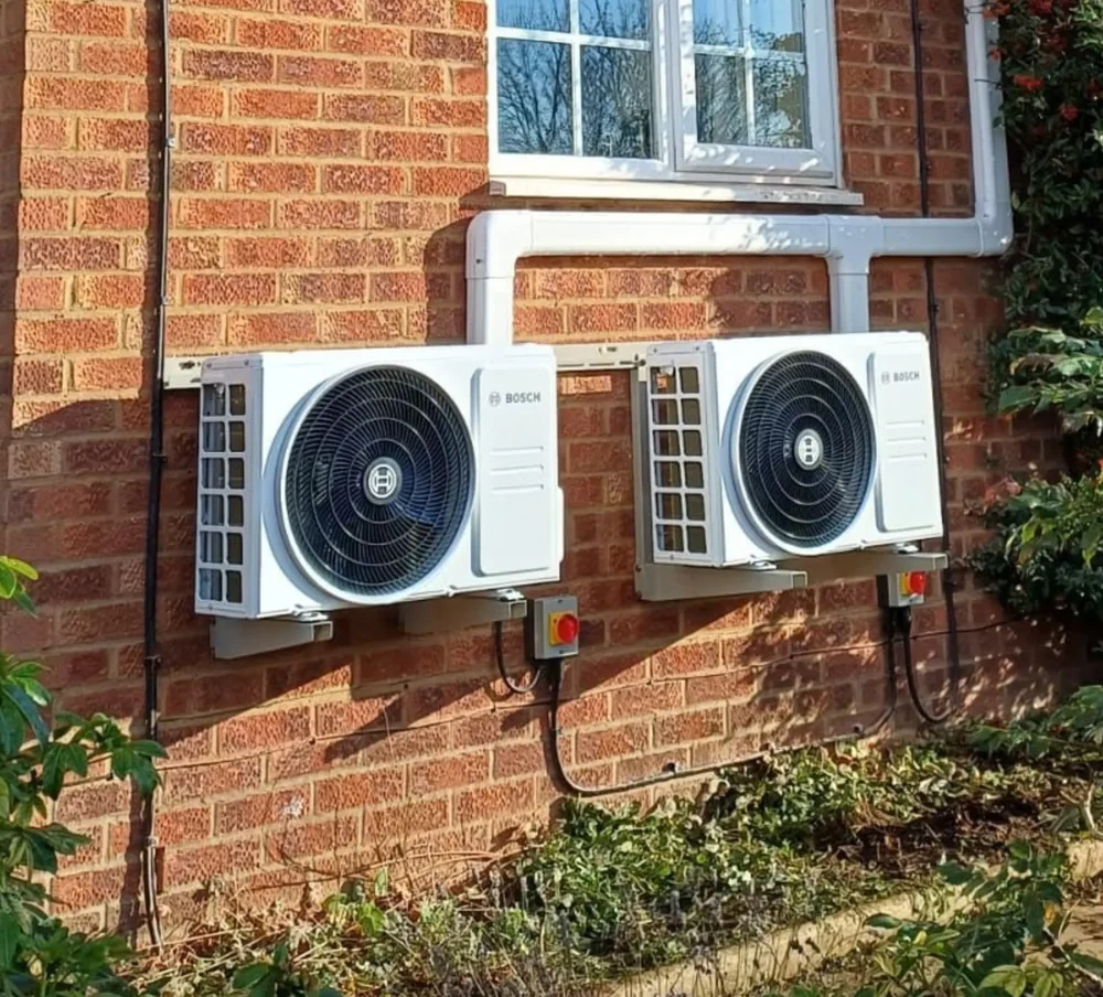 Two Bosch outdoor units fitted to a brick wall