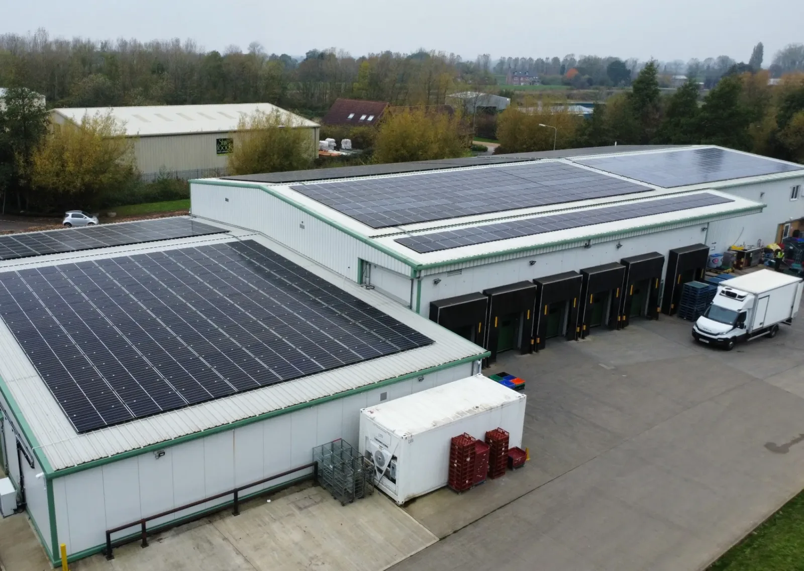 Aerial view of the Accent Fresh distribution depot with solar panels across its roofs, a refrigerated lorry at the loading bays