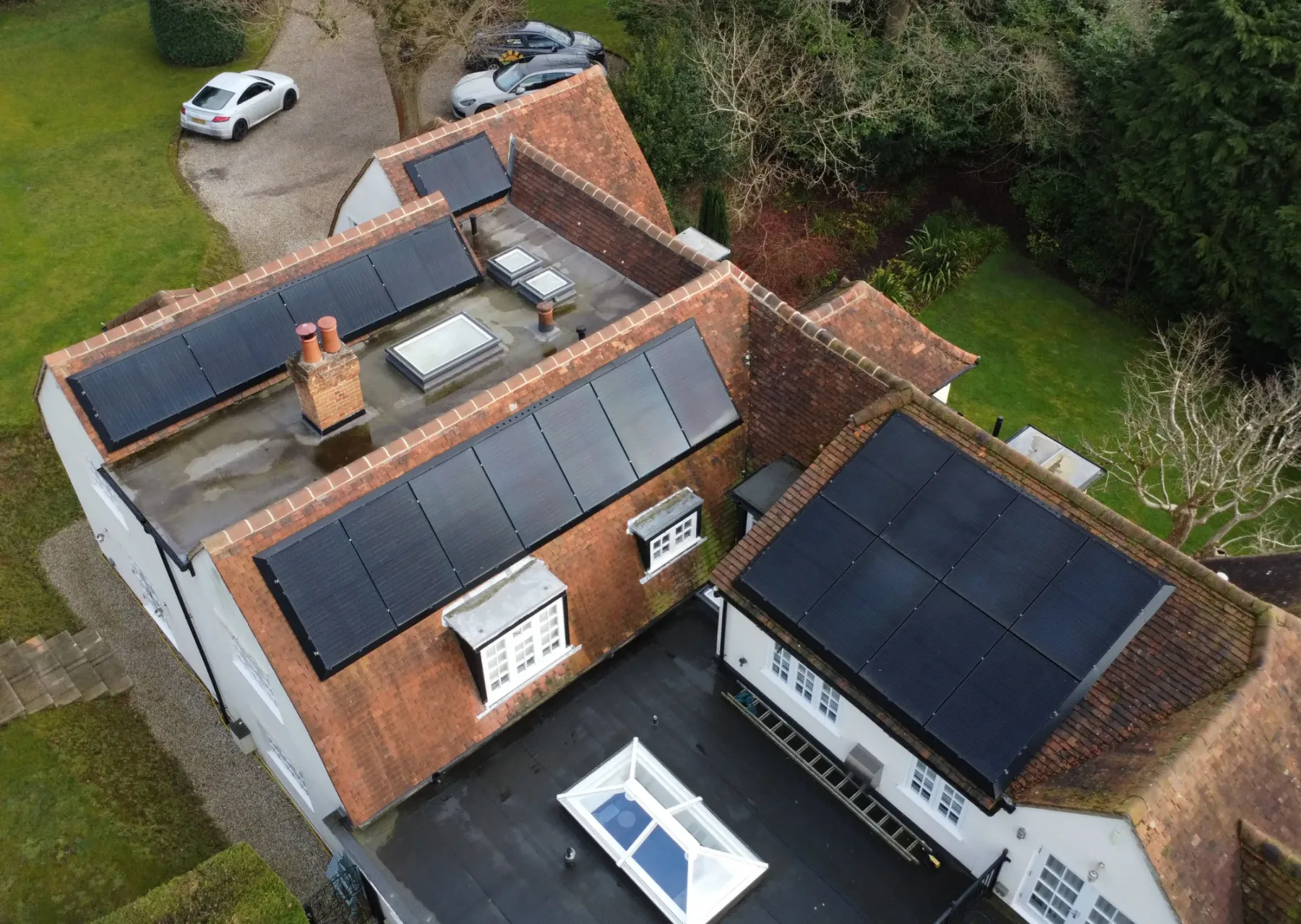Aerial view of Andrew's home with black solar panels across its tiled roofs