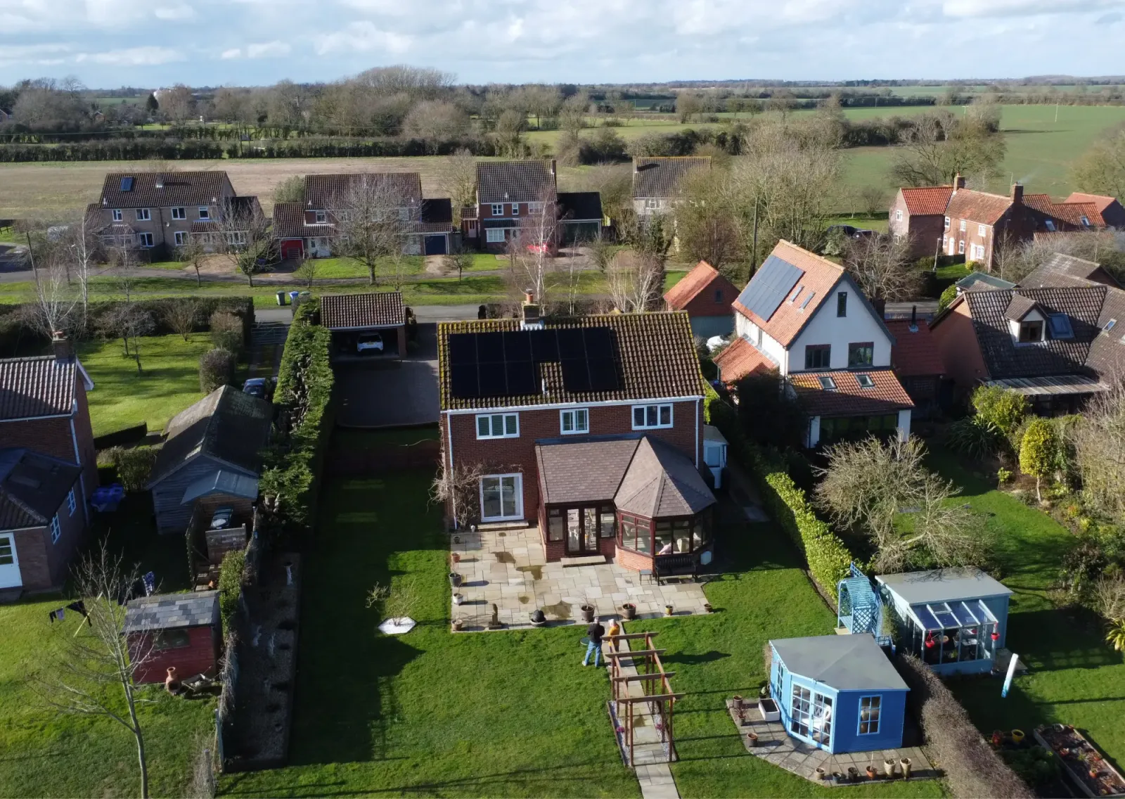 Aerial view of Alan's village home with black solar panels on the roof