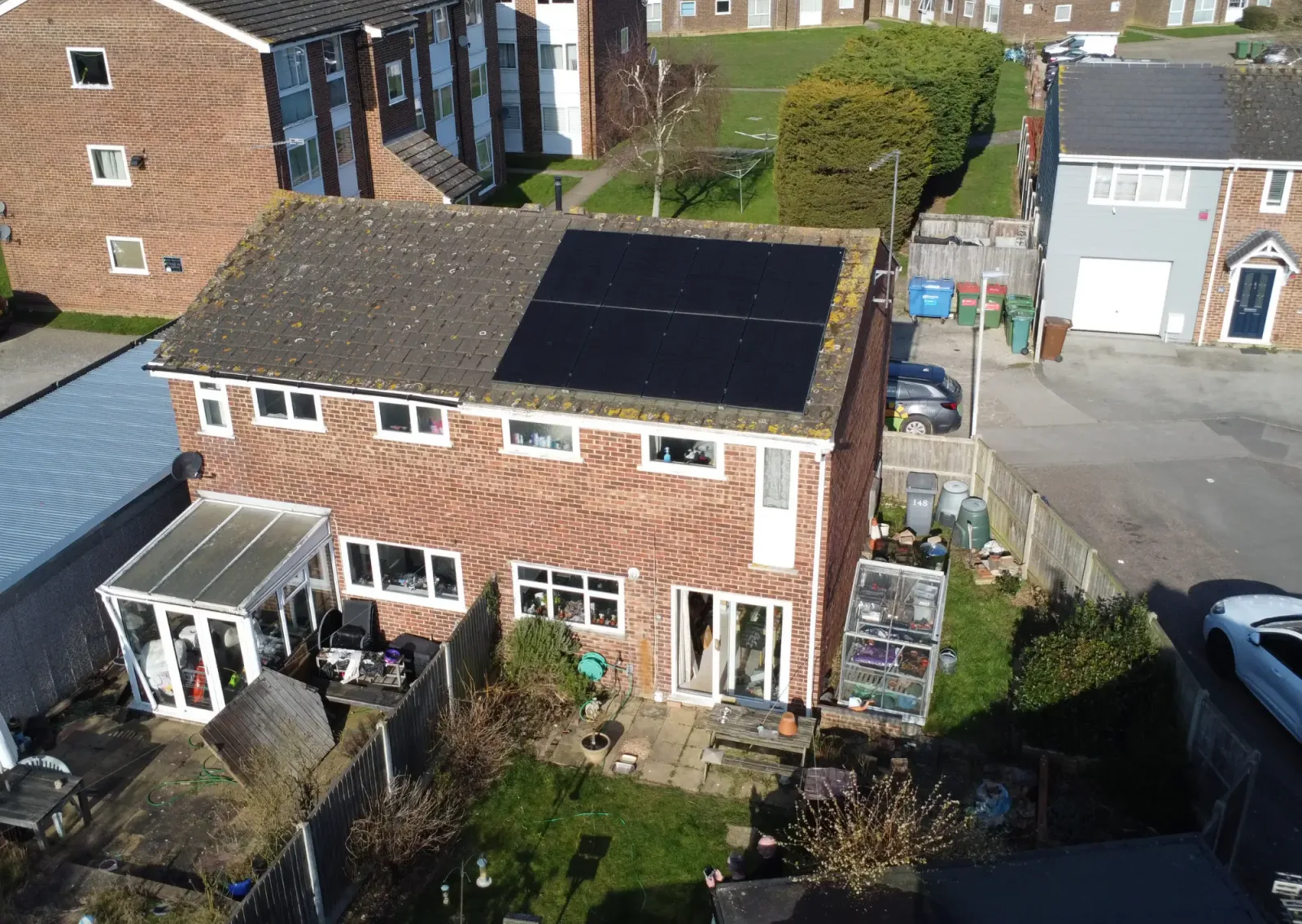 Aerial view of Dominic's semi-detached brick home with black panels on the south-facing roof