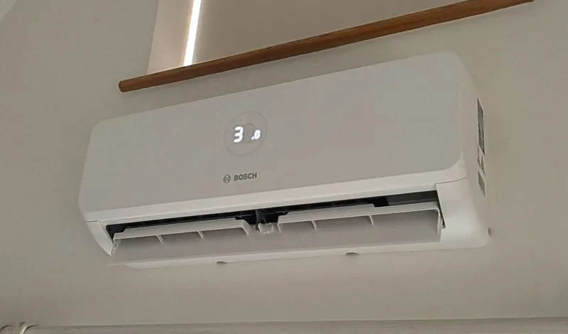 A Bosch indoor wall unit with its louvres open and a wooden rail above it