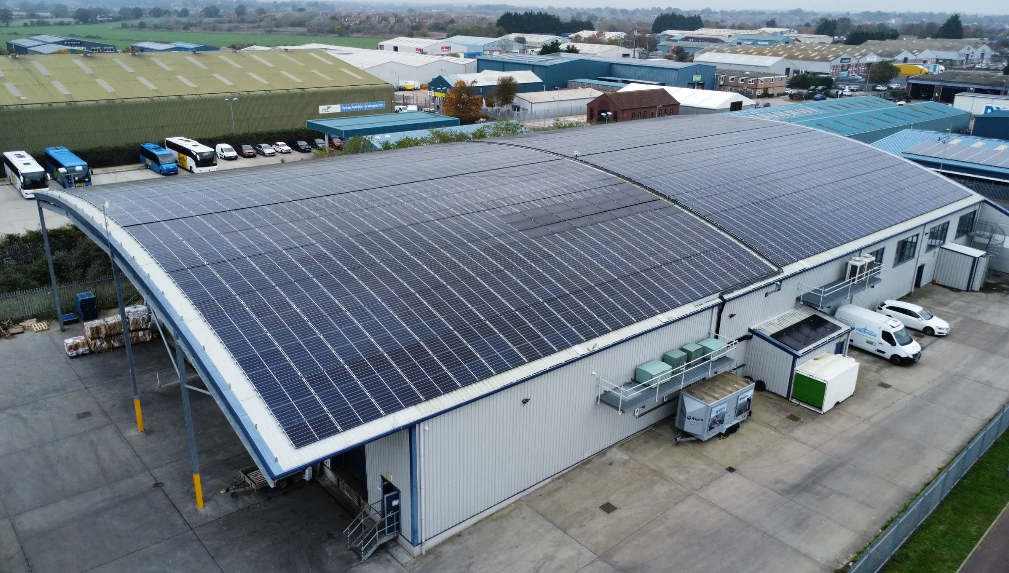 A warehouse with a curved roof covered in solar panels