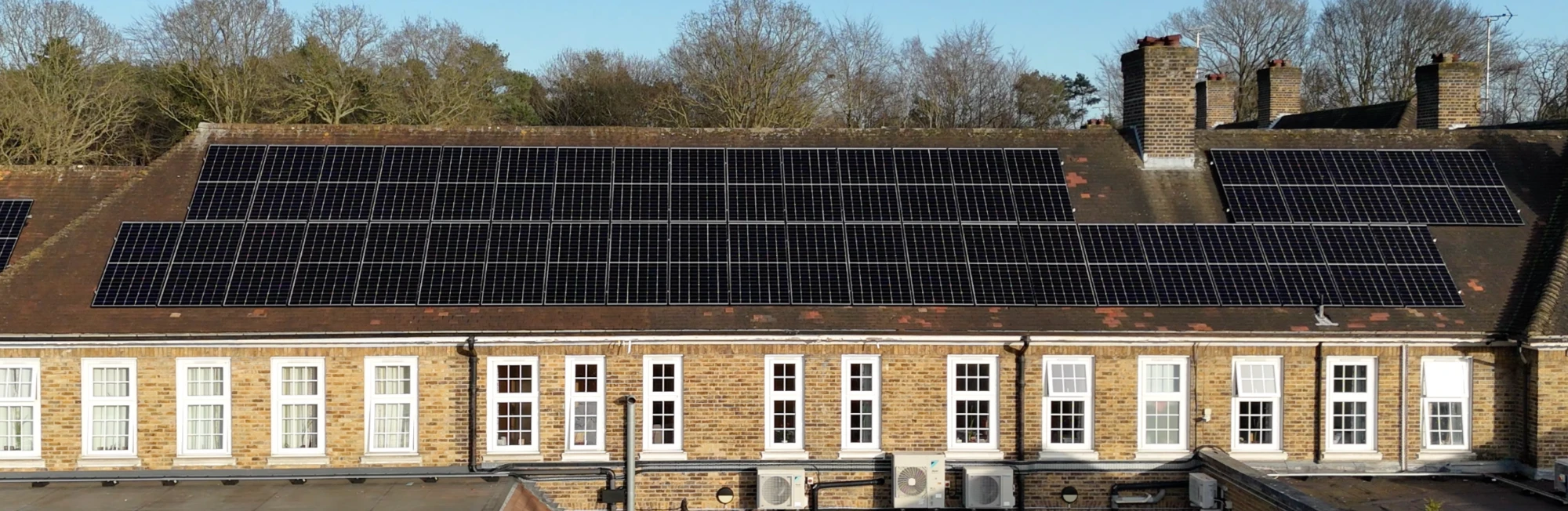 A building with a tiled roof full of solar panels